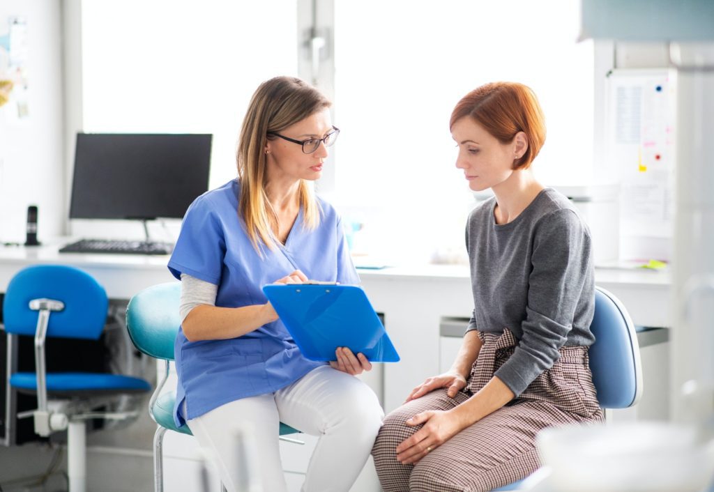 A dentist talking to woman in dentist surgery, a dental check-up